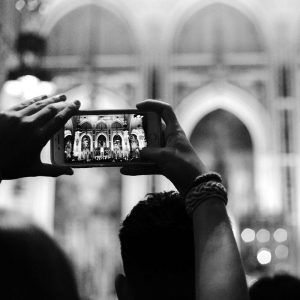 Frau fotografiert Kirchenfenster.